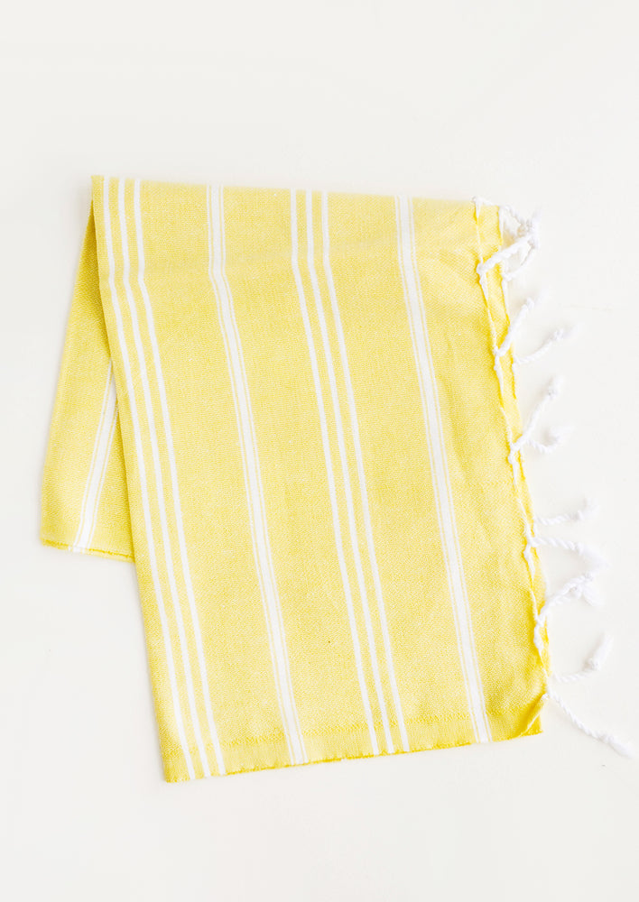Cotton towel with white stripes in yellow, twisted fringe on ends