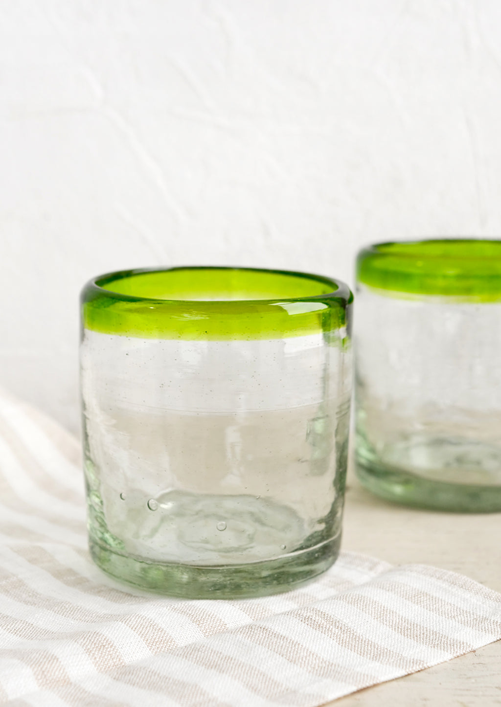 Verde: A heavy rocks glass in natural glass with colored green rim around top.
