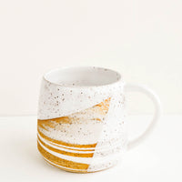 1: A ceramic mug with a handle in swirled ivory and brown clay with speckled white glazed rim.