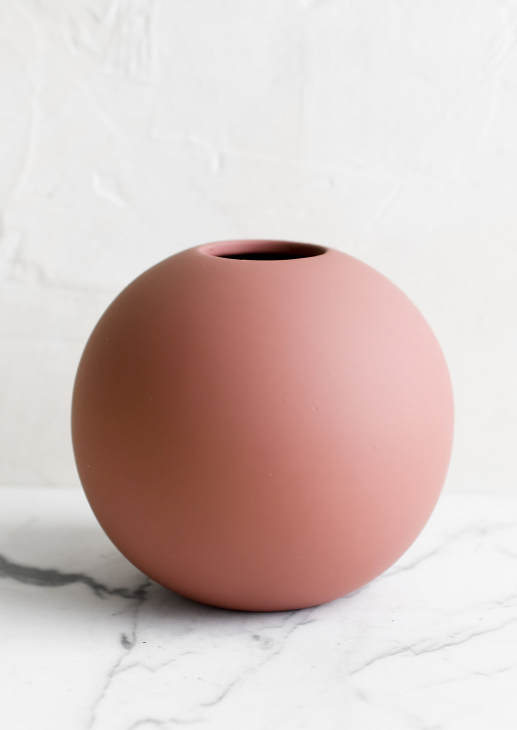 2: A round matte orb-shaped vase in dusty rose color.