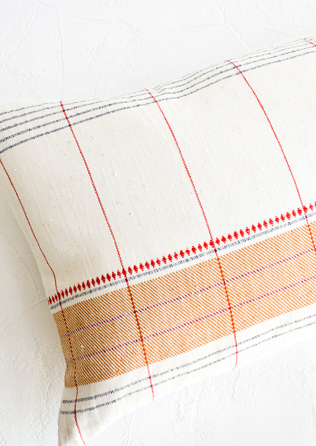 2: Throw pillow with intersecting stripes and embroidery