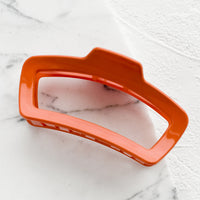 Persimmon: A rounded rectangle hair claw in persimmon.