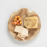 2: A round teak board with cheese and crackers.