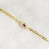 2: A gold chainlink bracelet with baguette ruby and crystal charm.