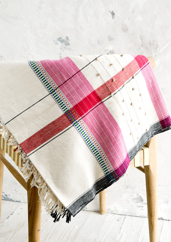 A woven cotton throw in a mix of colors and stitches.