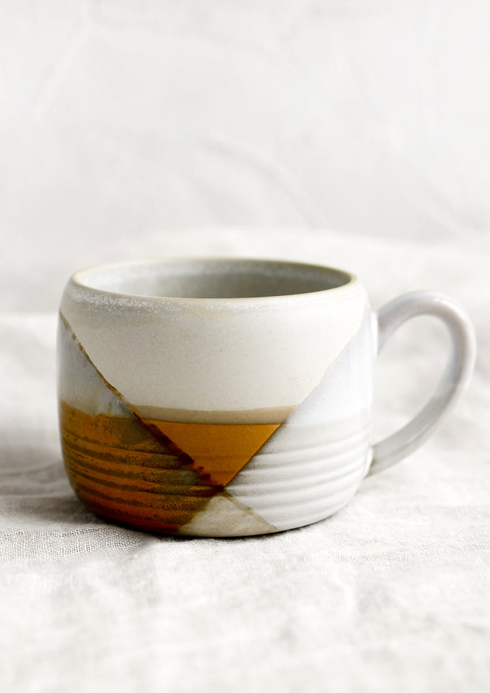 3: A mug with mix of brown and white glazes forming geometric pattern.