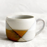 3: A mug with mix of brown and white glazes forming geometric pattern.