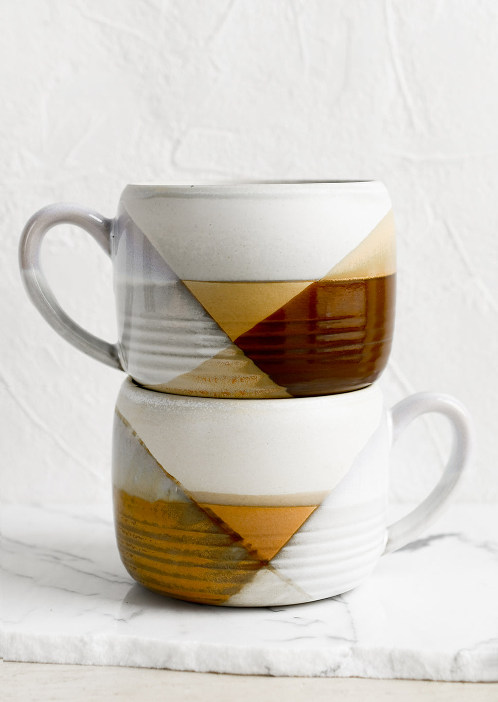 4: A mug with mix of brown and white glazes forming geometric pattern.