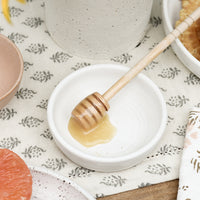 Matte White: A small white ceramic bowl with honey dipper.