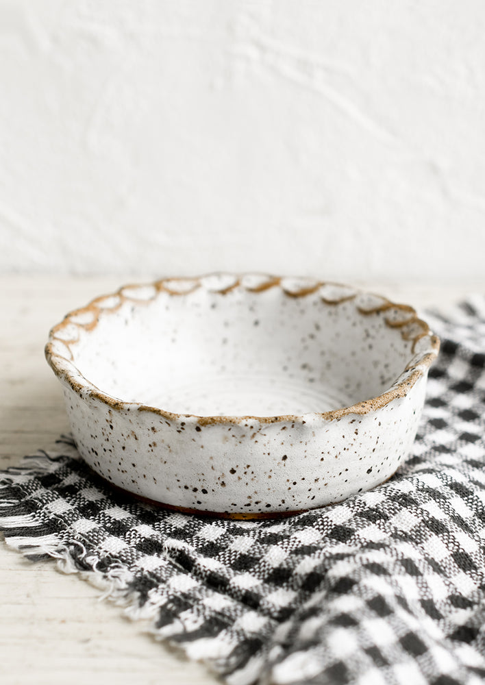 Speckled White: A small ceramic bowl with pinched rim in speckled white glaze.