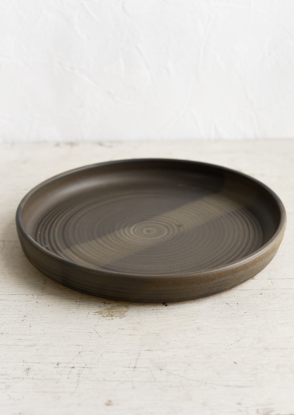 Matte Earth: A shallow serving plate in matte dark brown.