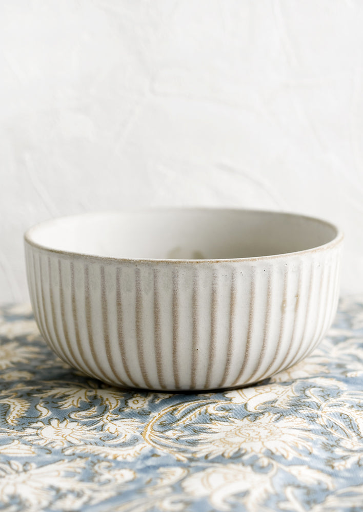 A soft white, natural glaze round serving bowl with ridge texture.
