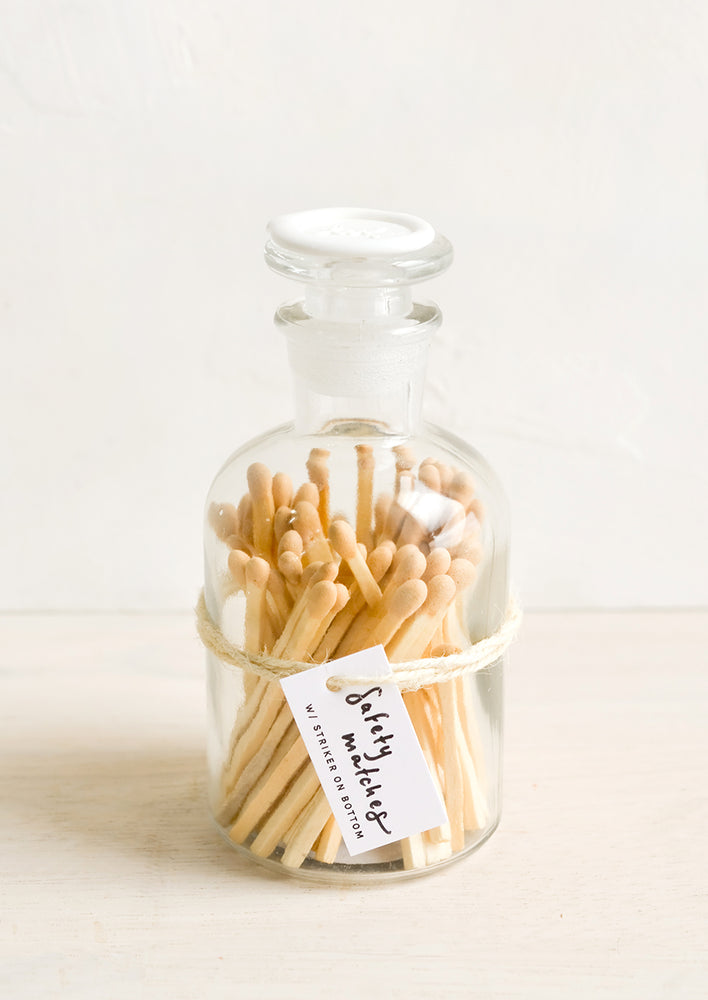 Safety matches with nude tips in a vintage-style glass apothecary jar with white wax seal on lid.