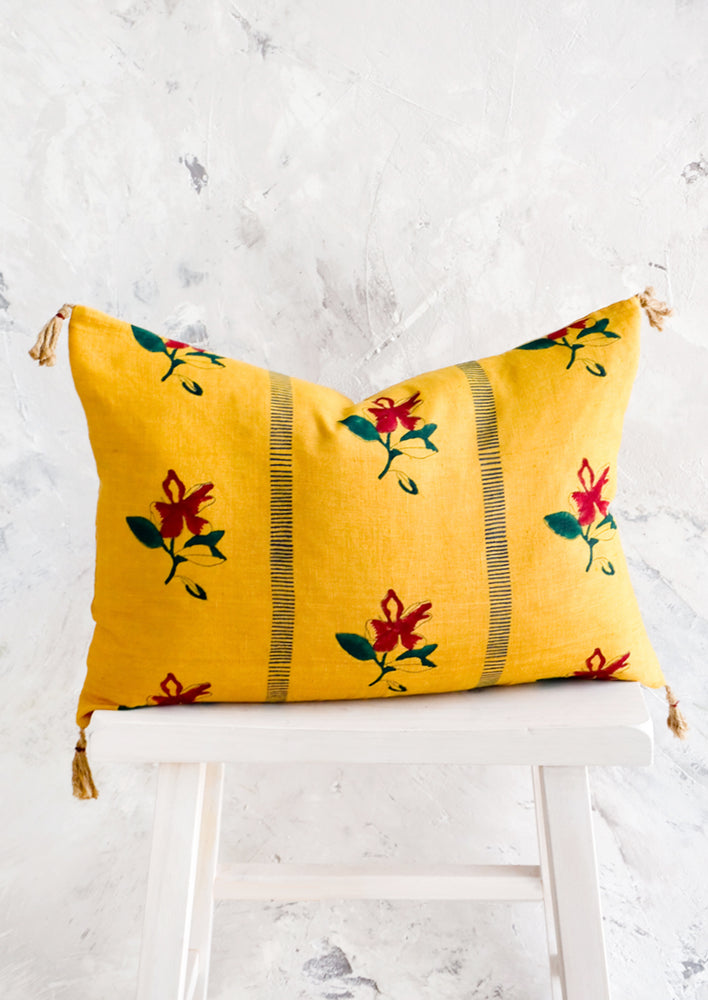 Block printed lumbar pillow in mustard yellow fabric with red flowers