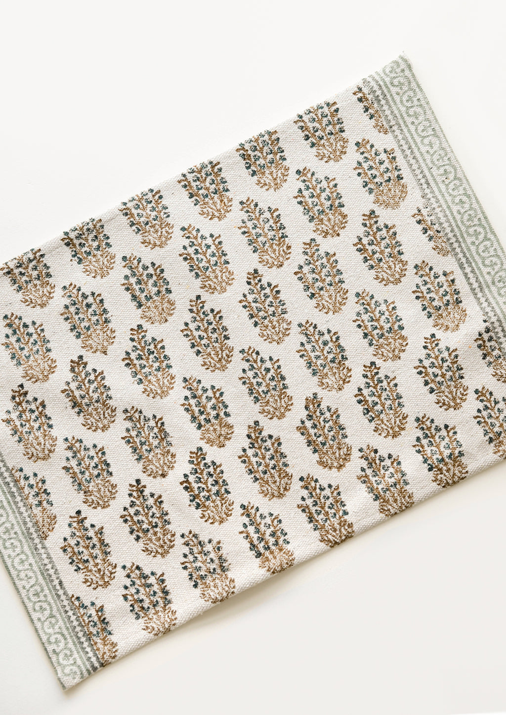 3: An ivory rectangular cotton placemat with green floral pattern.