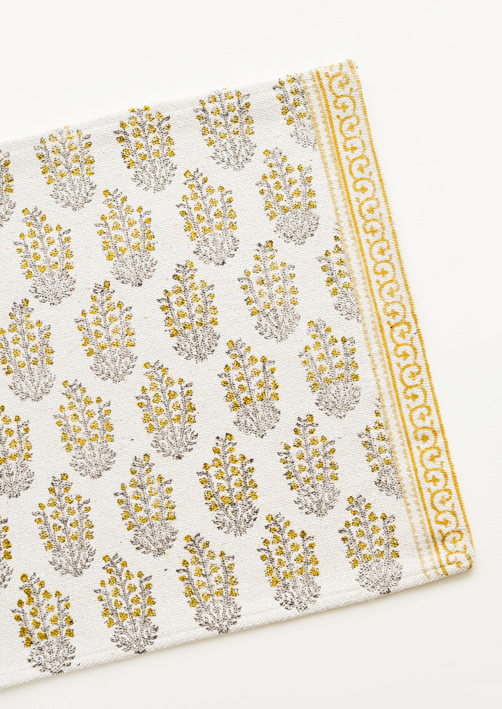 1: An ivory rectangular cotton placemat with yellow floral pattern.