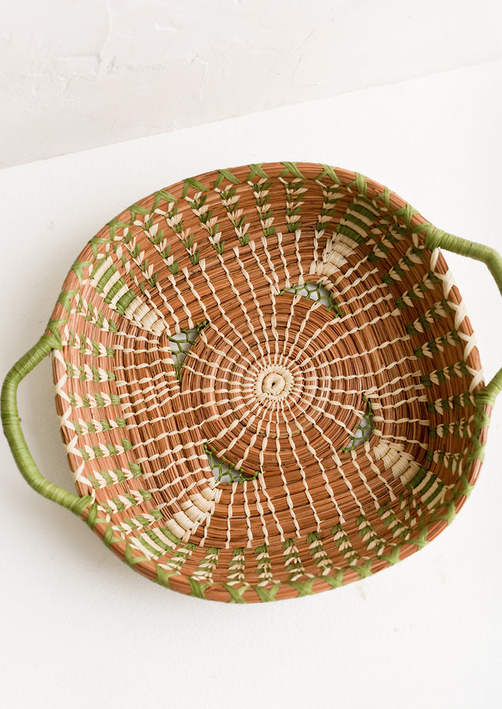 1: A shallow basket in rounded square shape with rectangular green handles at sides.