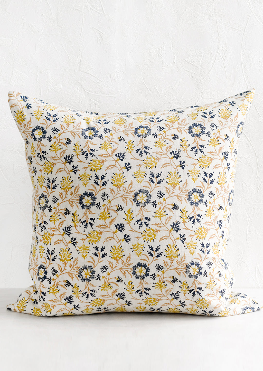 1: A block printed pillow in navy, brown and yellow floral print on natural linen.