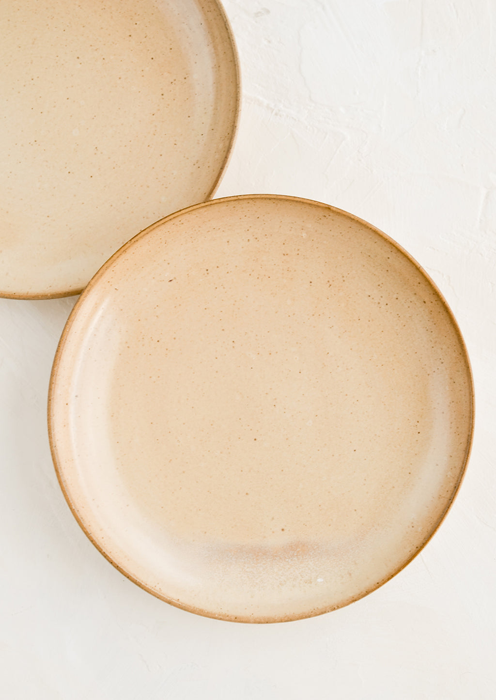 1: Two round side plates in a speckled tan glaze.