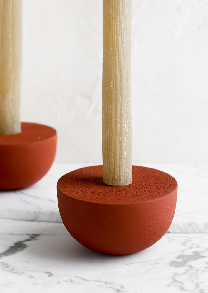 1: Red half-sphere taper holders with candles.