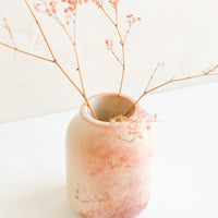 Short: A marbled pink soapstone vase with dried pink flowers.