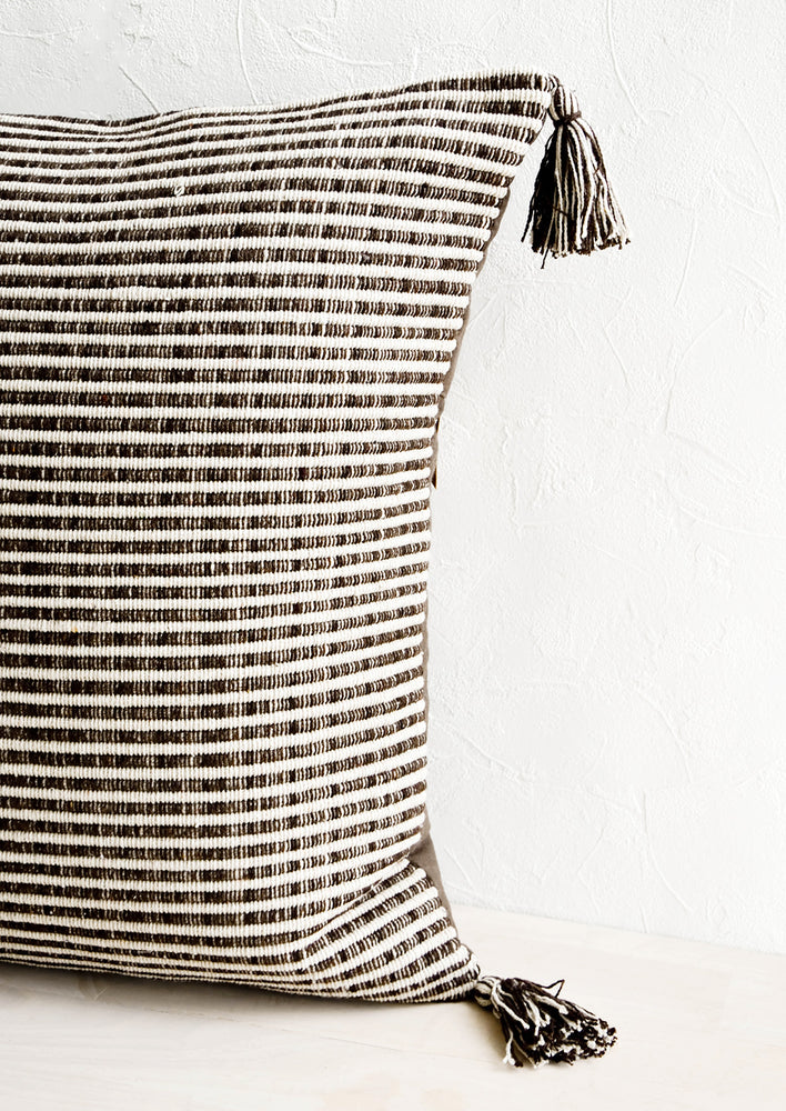 3: Textured, striped woven cotton pillow in dark brown and ivory with matching tassels at corners