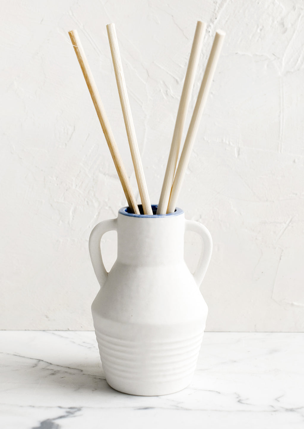 Cliff & Hinoki Wood: A ceramic reed diffuser bottle in white.
