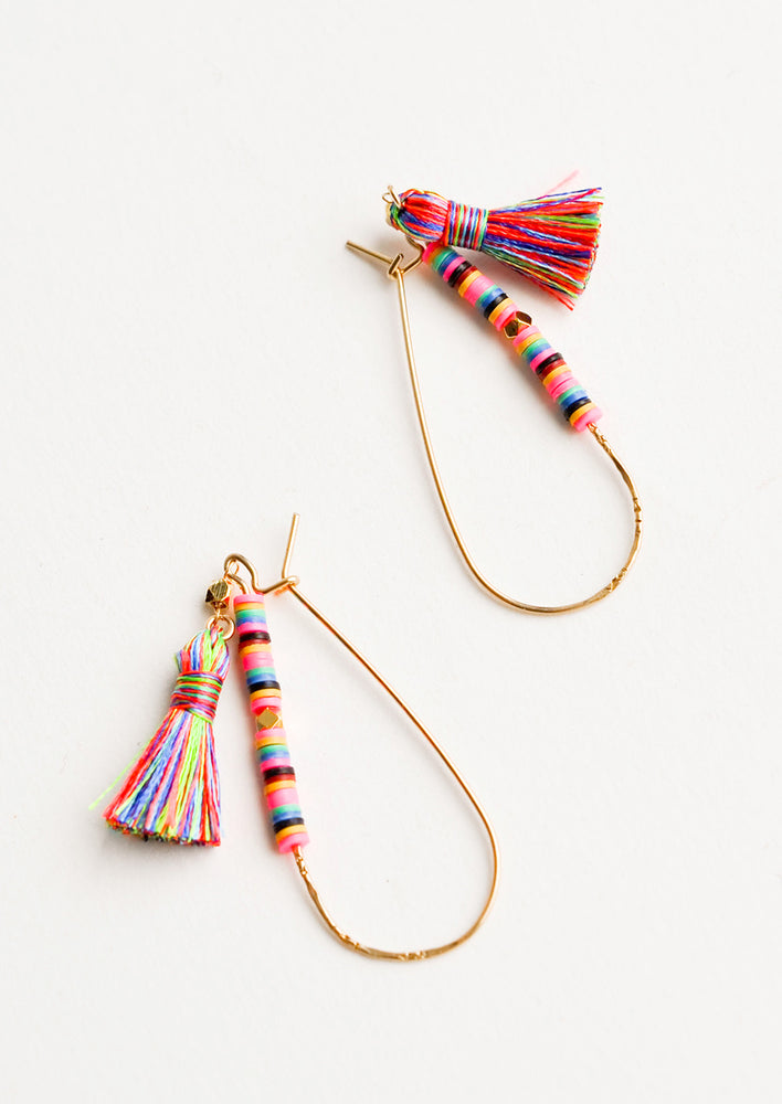 1: Thing gold teardrop earrings with bright multicolored beading and tassel on one half.