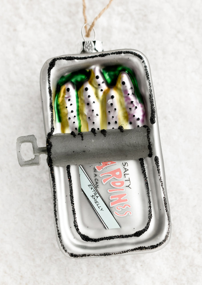 A glass holiday ornament of sardines in a tin.