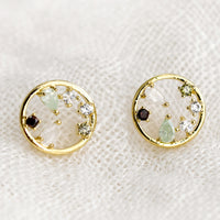 2: A pair of gold circular stud earrings with a mix of color and shape crystals inside the circle.