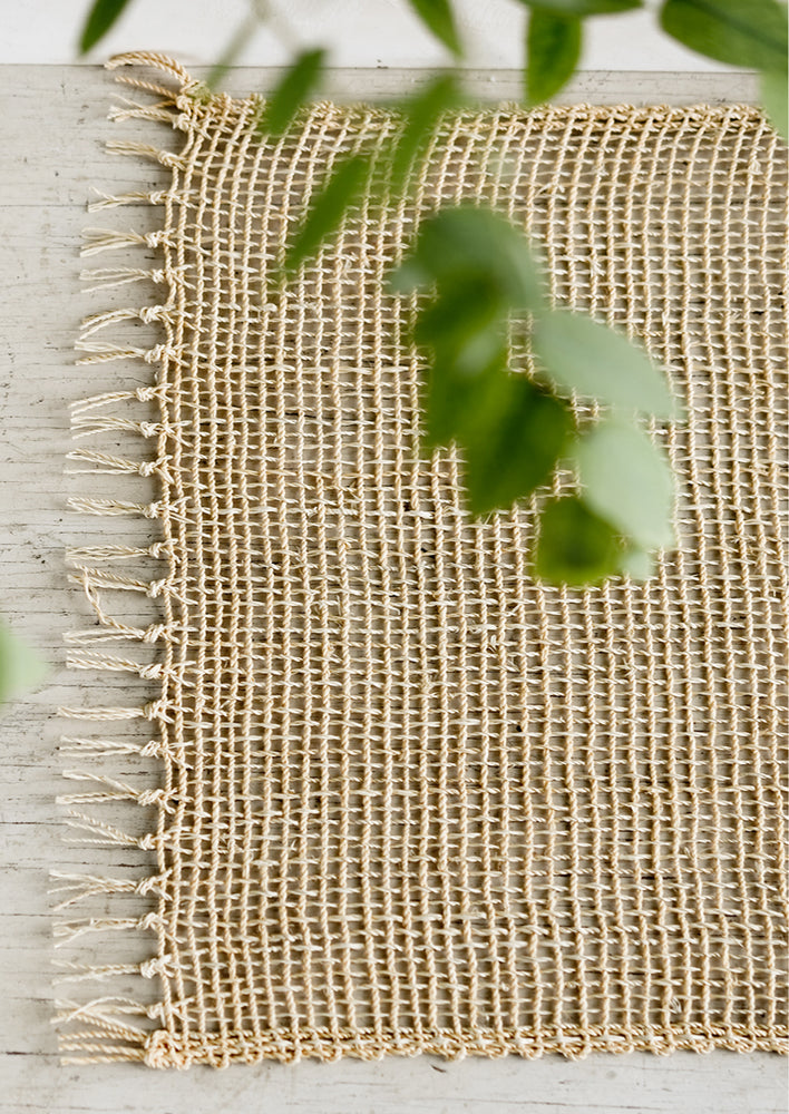 An open weave placemat made from natural straw.