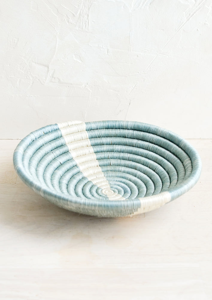 A small sweetgrass catchall bowl in blue with white stripe.