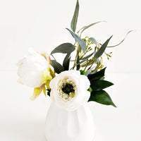 1: Small and round mini ceramic vase in white shown with floral arrangement