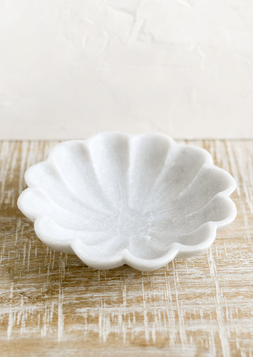 2: A shallow marble dish with curvy scalloped design.
