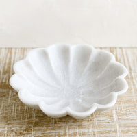 2: A shallow marble dish with curvy scalloped design.