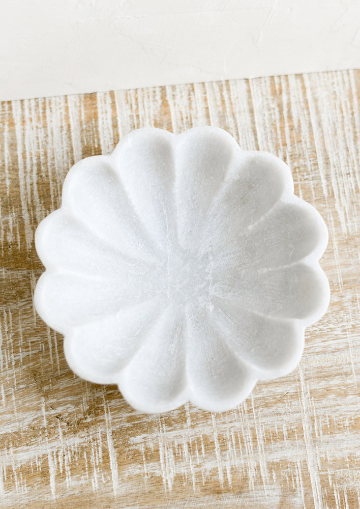 A shallow marble dish with curvy scalloped design.