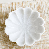 1: A shallow marble dish with curvy scalloped design.