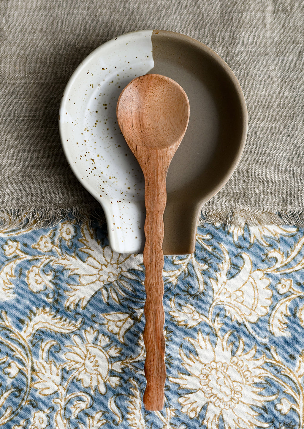 2: A wooden spoon on a ceramic spoon rest.