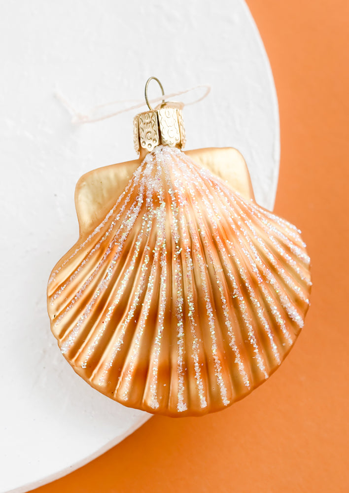 A glass ornament in the shape of scalloped shell.