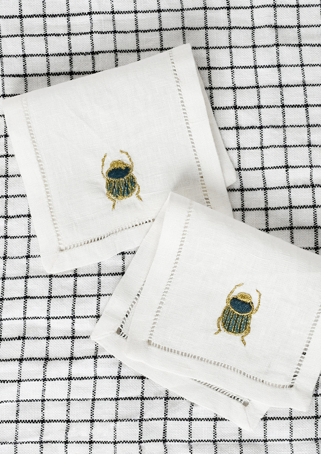 1: A pair of scarab embroidered cocktail napkins.