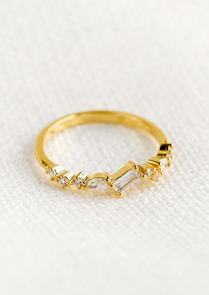 A gold ring with askew clear crystals in mixed cuts.