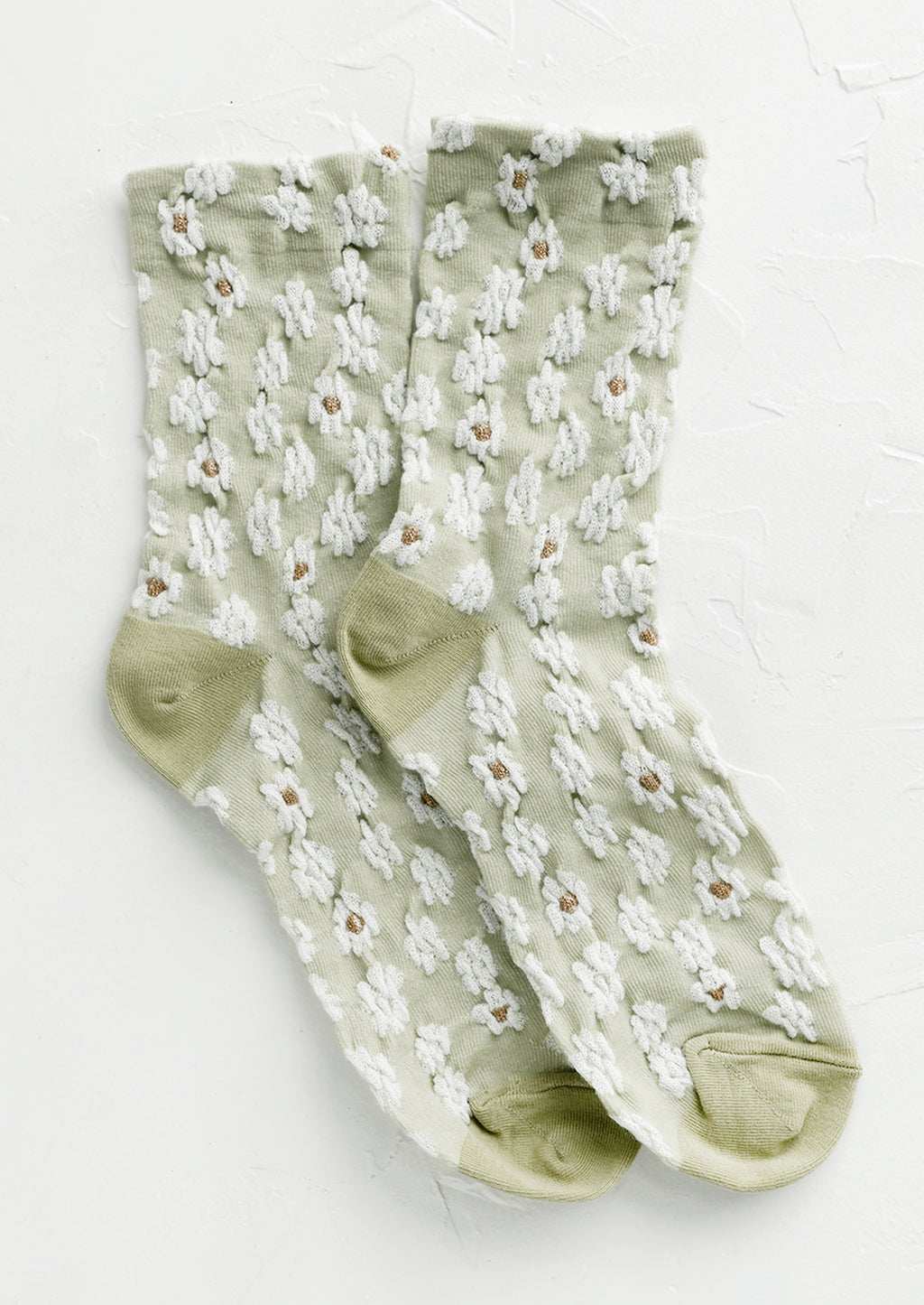 Mint: A pair of non-sheer yellow socks in mint with allover white daisy pattern.
