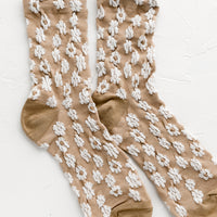 Tan: A pair of non-sheer yellow socks in tan with allover white daisy pattern.