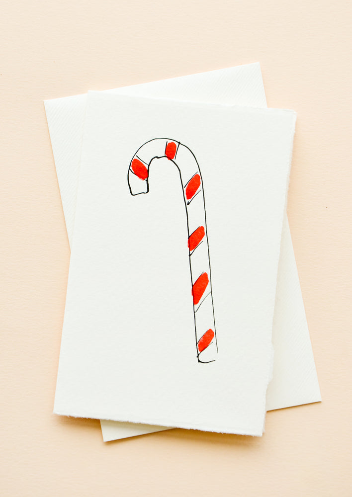 1: A white greeting card with illustration of a candy cane, with a white envelope.
