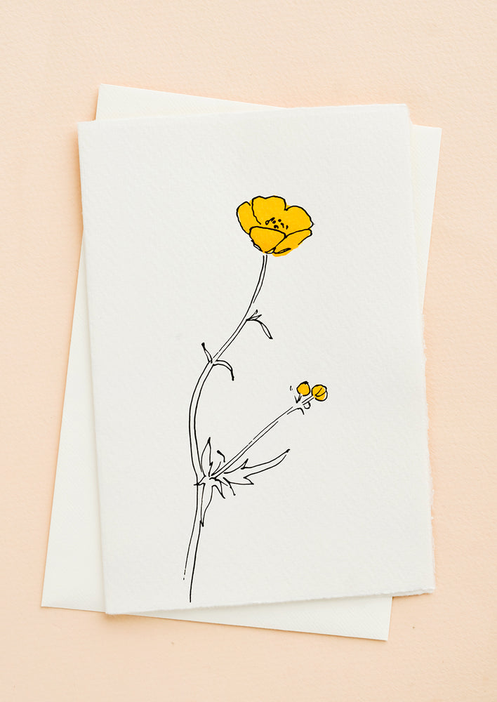 A white greeting card with a hand painted illustration of a buttercup flower.