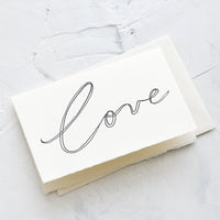 1: A letterpress printed greeting card on white handmade paper with "Love" script on front in black letters.