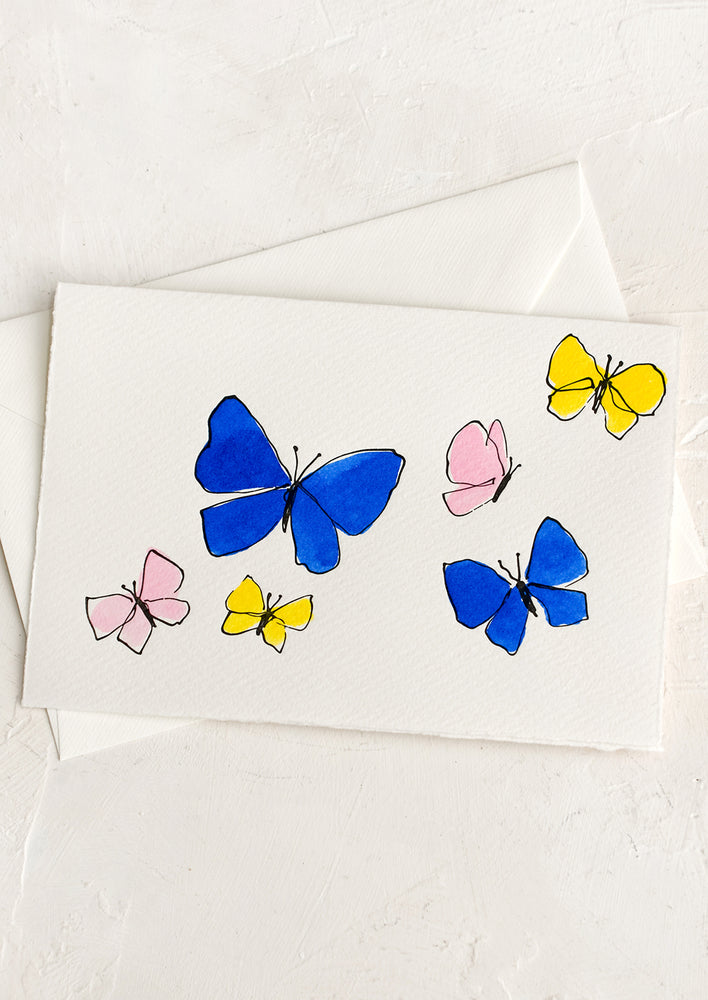 1: A card with blue, pink and yellow hand painted butterflies.