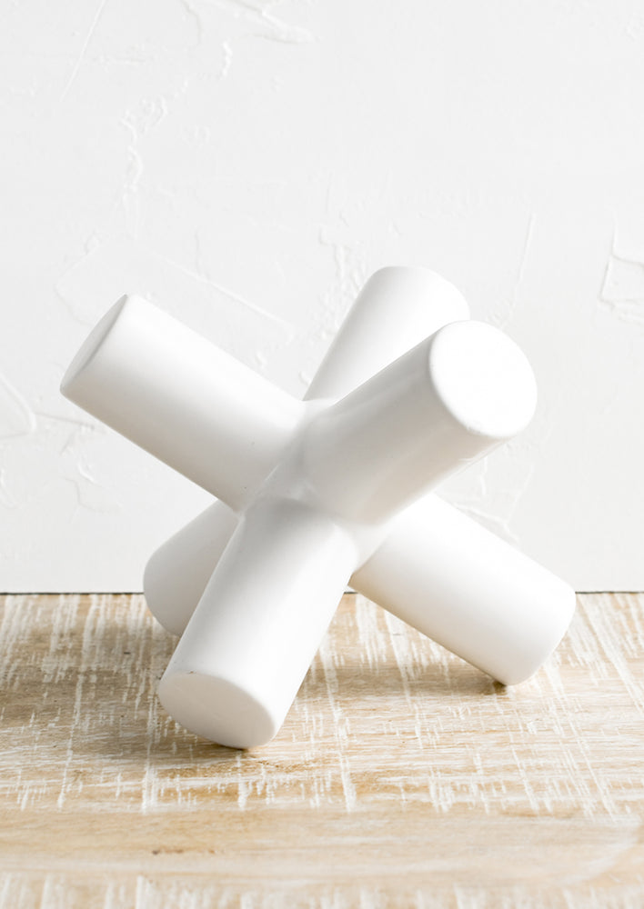 A decorative sculptural object in crossed X shape.