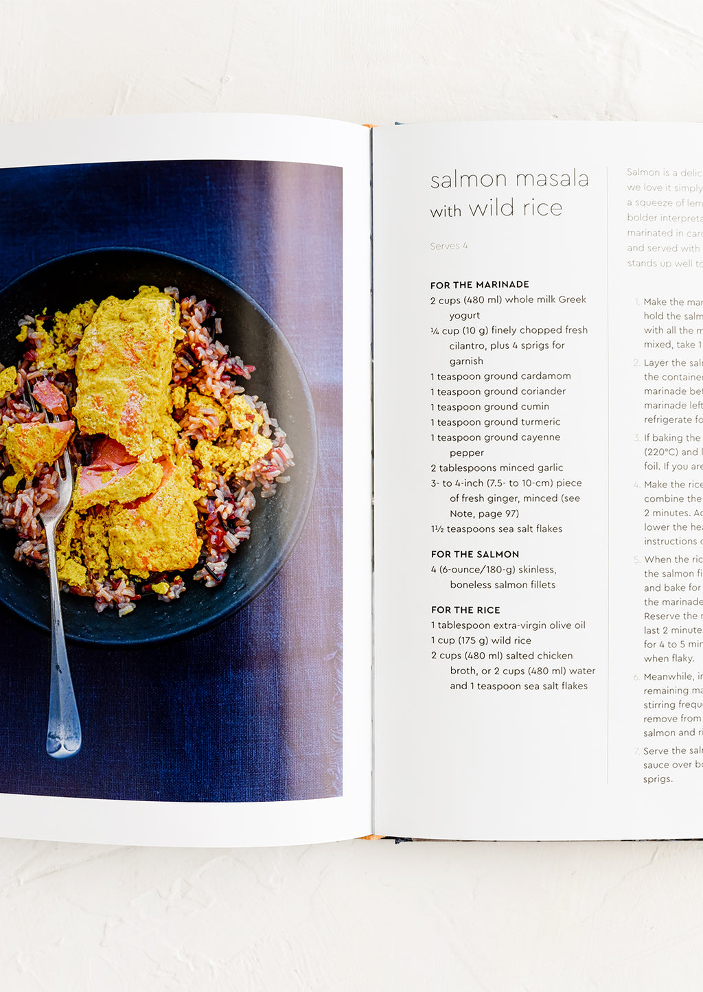 3: A cookbook open to a page with recipe for salmon masala with wild rice.