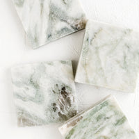 1: Four square marble coasters with variegated tones of green, white and grey.